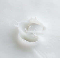 Cosmetic container white lotion droplet fly splashing. Milk lotion pour float to cosmetic bottle. Moisturizer lotion explosion spill. White background isolated high speed shutter freeze top view