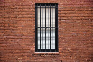 Window with black metal bars on a brick building