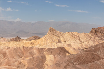 Fototapeta premium Scenic view of summit peak Manly Beacon seen from Zabriskie Point, Badlands, Furnace creek, Death Valley National Park, California, USA. Erosional landscape of multi hued Amargosa Chaos rock formation
