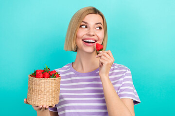 Portrait of adorable satisfied woman stylish t-shirt hold basket with strawberry look empty space isolated on teal color background