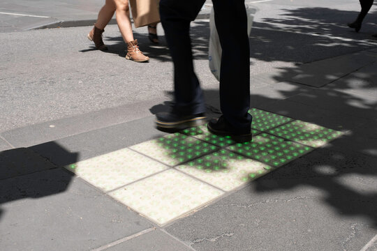 Pedestrian crossing lights embedded in the pavement for phone zombies that never look up at pedestrian crossings in Melbourne, Australia. Bright green square glowing tiles in action - Powered by Adobe