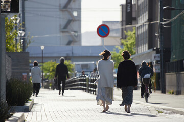 京都の朝の街を散歩している若い女性の後姿