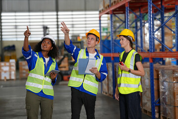 Multiethnic industrial workers checking their logistic lists while working with transportation of goods in warehouse