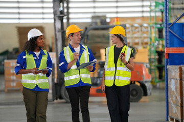 Multiethnic industrial workers checking their logistic lists while working with transportation of goods in warehouse