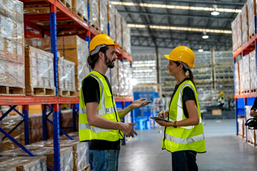 Multiethnic industrial workers checking their logistic lists while working with transportation of goods in warehouse