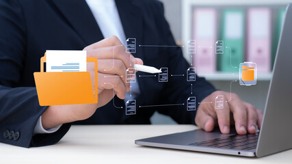 Businessman working of laptop with virtual document management concept, online documentation...