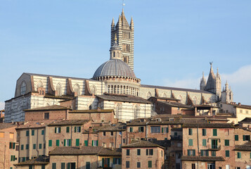 Fototapeta na wymiar Panorama of Siena with the red houses, the cathedral in Italian Romanesque-Gothic style and the Torre del Mangia overlooking Piazza del Campo.