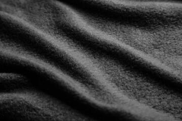 Fototapeta na wymiar Texture of warm woolen fabric with folds. Gray wavy felt back.