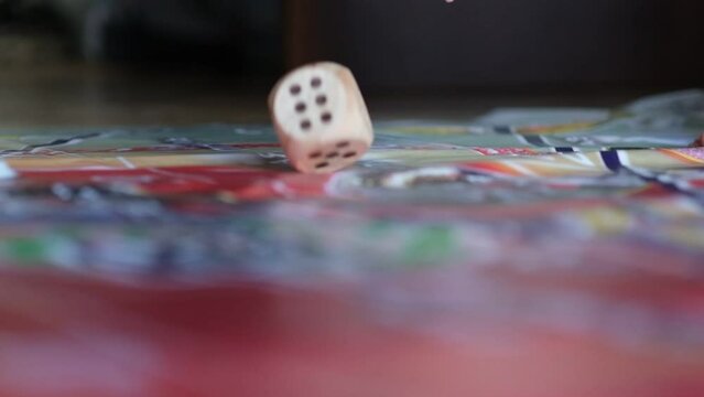 woman's hand tossing a large wooden die represents the unpredictability of life, and how we must learn to adapt and find balance amidst constant change.