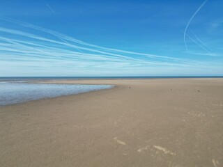 Aerial view of golden sand beach with low tide and blue sky background. Taken in Lytham Lancashire England. 