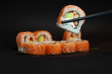 sushi with chopsticks - obrazy, fototapety, plakaty