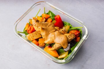 Closeup of grilled chicken and hummus protein on a glass plate