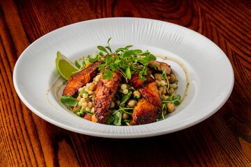 Closeup of chicken salad in a white plate on the wooden table