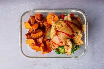 Top view of healthy lunch with chicken meat and pumpkin in the glass container