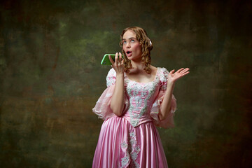 One charming blond princess wearing fancy pink dress and recording audio massage over vintage texture background. Gadgets in medieval age © Lustre Art Group 
