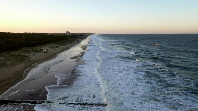Aerial shot of the waves breaking at Rehoboth Beach, Delaware at sunset