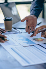 Diverse colleagues brainstorm to discuss financial statistics at an office meeting. Finance, teamwork, data chart concept, graph, financial planning and company vertical image