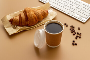 Coffee break in the office. Paper cup of coffee with keyboard, top view
