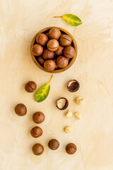 Shelled macadamia nuts in bowl with green leaves. Protein food