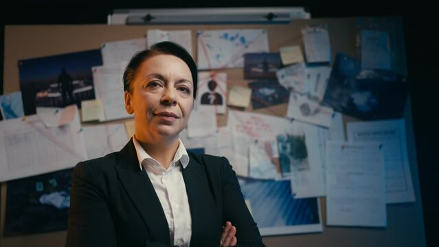 Portrait of confident middle-aged woman detective near investigation board