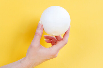Young woman is holding a styrofoam ball in her hand.