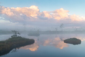 Fototapeta na wymiar Beautiful shot of a fog over the calm lake at sunset