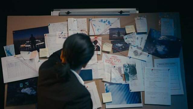 Middle-aged female detective trying to solve murder using investigation board 