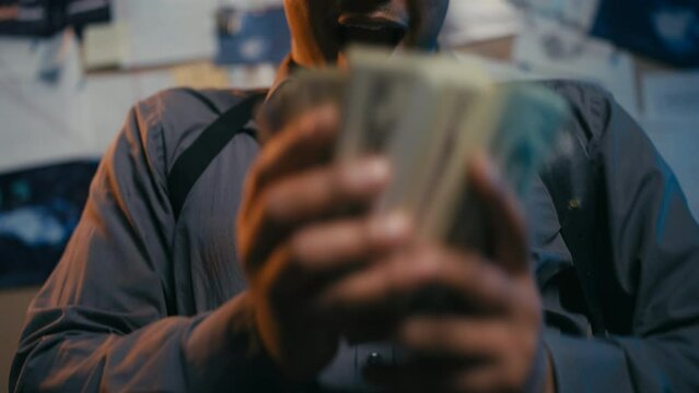 Happy crooked detective counting money bribe, police misconduct and corruption