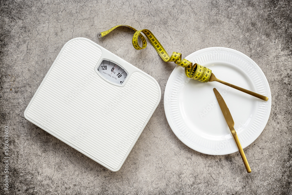 Wall mural Tape measure with dinner cutlery and weight scales. Dieting and weight control concept