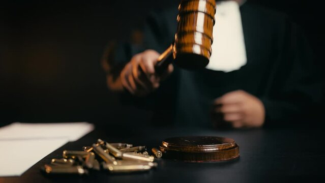 Judge striking gavel, bullet cases on table, gun control law, firearm regulation