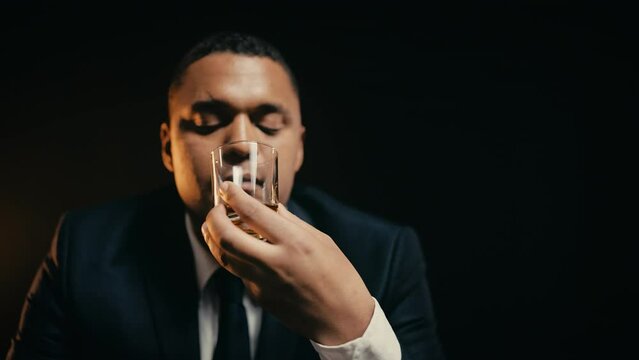 Rich African American man drinking whiskey, enjoying flavor, degustation