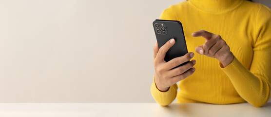 Close up view of young Asian woman using smartphone at her room with copy space.