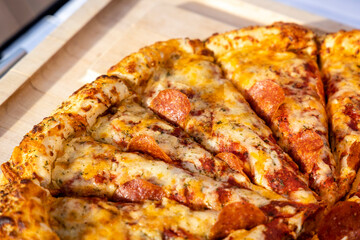 A closeup section of a pizza being Served in an outdoor setting for an event.