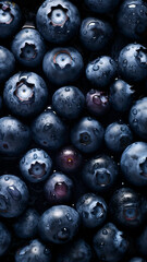 Fresh Blueberries background, adorned with glistening droplets of water, top down view.