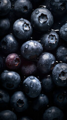 Fresh Blueberries background, adorned with glistening droplets of water, top down view.
