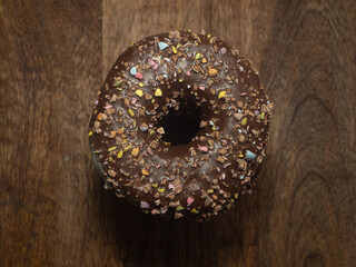 A chocolate donut with sprinkles