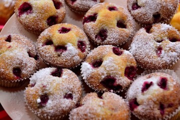 Closeup of muffins with icing sugar and jam glaze.