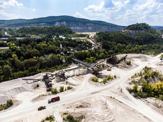 Aerial view of a mining complex on the slope of a forested hill.