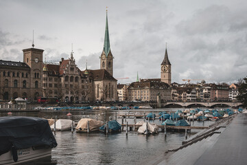 Fraumunster church in Zurich city Switzerland. Riverside view, boats parked on the river, Bridge in the distance, daytime, no recognizable people
