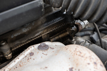 Cold car engine oil leaks. Dirty oil leaking from near the headgasket, visible oil stains on block....