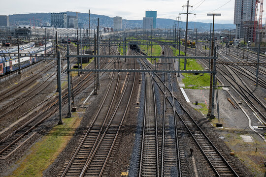 Several empty parallel train tracks in major rail hub in European city. Above view, trains, no people
