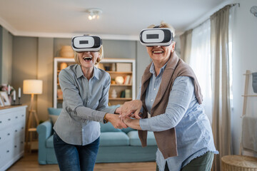 two Women mature senior females at home use virtual reality VR headset