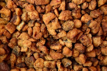 Close up fried salty boar pork greaves cut into pieces