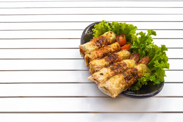 Traditional fried vietnamese spring rolls with pork, rice paper on black background side view