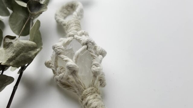 handmade macrame keychain design in natural colours.boho style quartz and knots. on white background. Close up video. Slow motion video. stock footage