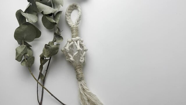 handmade macrame keychain design in natural colours.boho style quartz and knots. on white background. Close up video. Slow motion video. stock footage