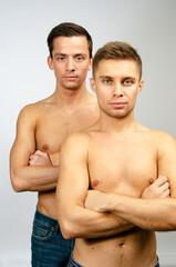 Two young attractive guys are posing in the studio. Beautiful gay couple in a relationship. Love and romance.