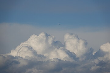 Gros nuages blancs et un avion dans un ciel tempétueux