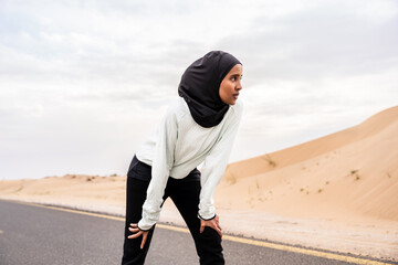 Beautiful middle-eastern arab woman wearing hijab training outdoors in a desert area - Sportive athletic muslim adult female wearing burkini sportswear doing fitness workout - Powered by Adobe
