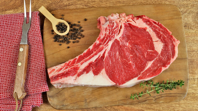 c&ocirc;te &agrave; l'os cru, en gros plan, sur une planche &agrave; d&eacute;couper